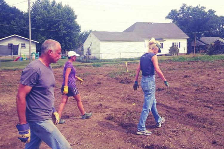 SCANNING THE GROUND — Gary Hogsett, Jodi Hayse and Anne Hogsett, left to right, scan the ground to make sure there were no unwanted items.