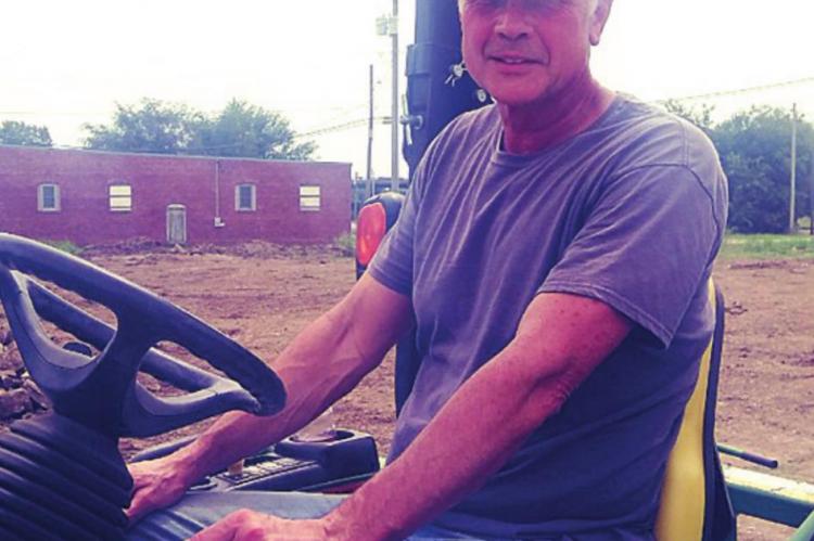 EQUIPMENT OPERATOR — Gary Hogsett takes his turn on the tractor at the future site of another community orchard.