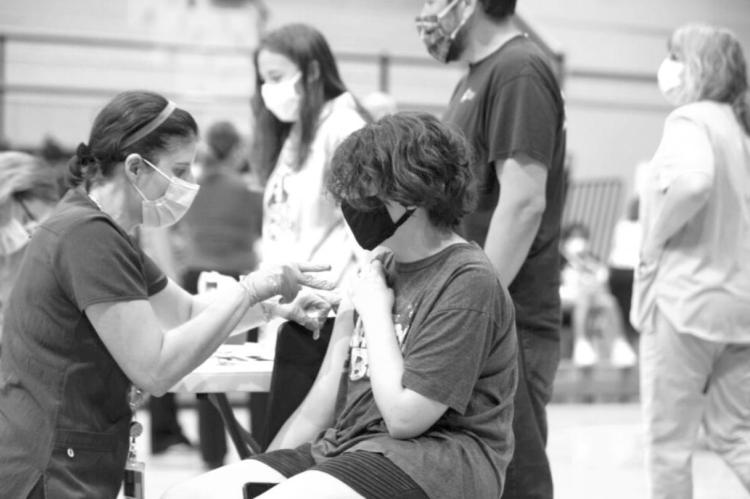 A 12-year-old student receives a COVID-19 vaccine during a clinic in August at Topeka High School. The Safer Classrooms Workgroup wants schools to encourage younger kids to get vaccinated as soon as federal regulators provide a green light. (Pool photo by Evert Nelson/The Capital-Journal)